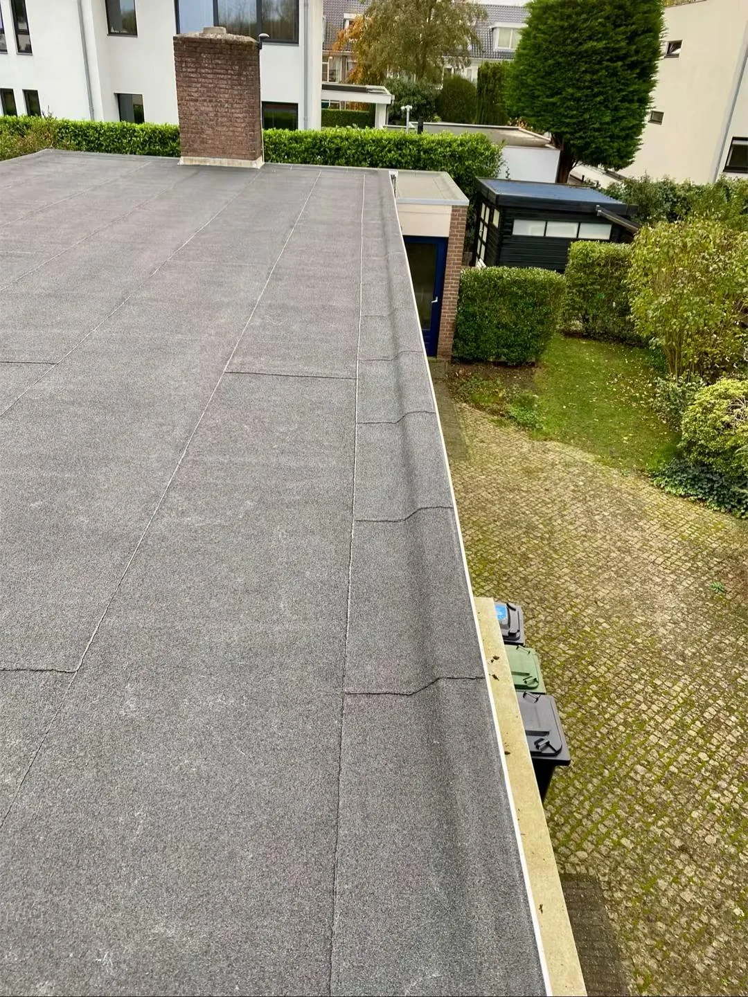 Lange dakrand langs een plat dak, van bovenaf gefotografeerd.