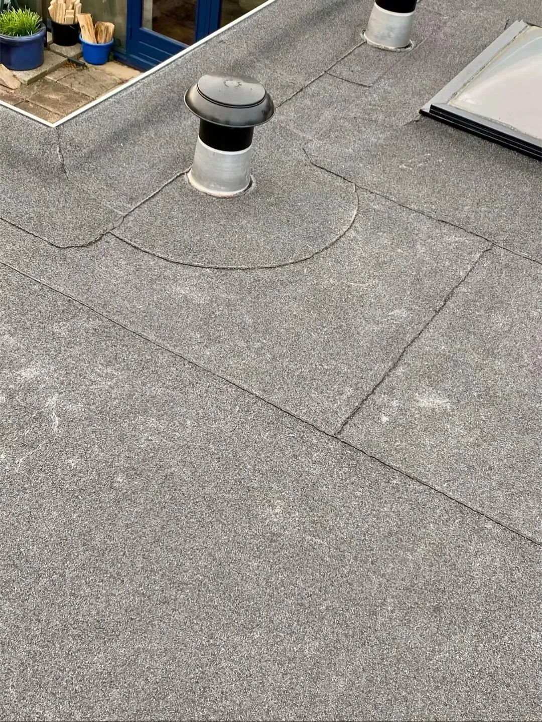 Ventilatiekap en de omliggende banen dakbedekking.