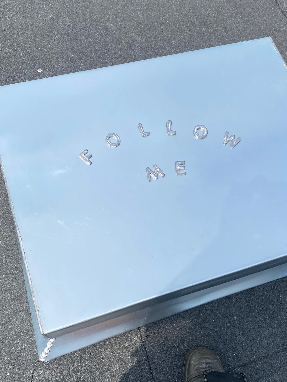 Los metalen plaatdeel met aangebracht letterwerk.